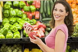 Woman shopping for bell peppers at a grocery store