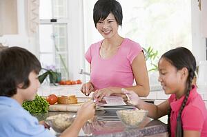 Children Enjoying Breakfast While Mother Is Preparing Food