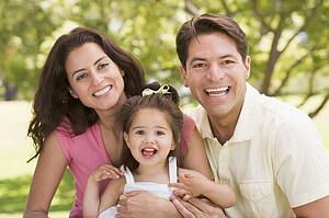 Family sitting outdoors smiling
