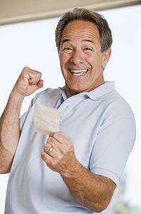Man with winning lottery ticket excited and smiling
