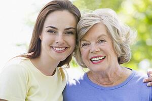 Two women outdoors embracing and smiling