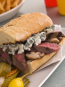 Steak and Roquefort Sandwich with Fries Gherkins and Chillies