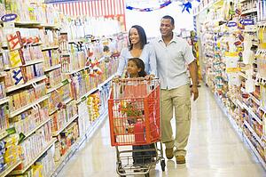 Mother and father with young daughter shopping at the grocery store.
