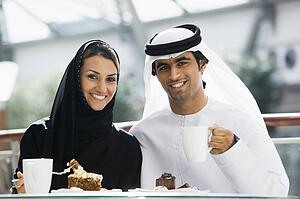 Couple at restaurant eating dessert and smiling (selective focus)