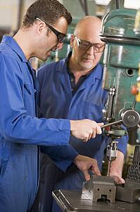 Two machinists working on machine