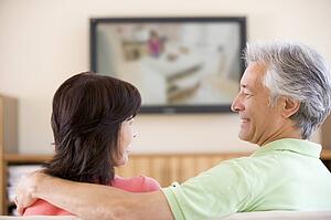 Couple watching television smiling