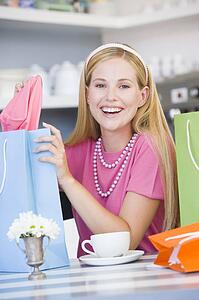 Young woman sitting at a table taking a break from shopping