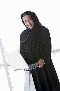Woman with laptop smiling (high key/selective focus)