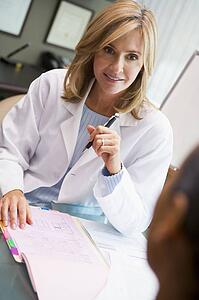 Doctor in consultation with man at IVF clinic (selective focus)