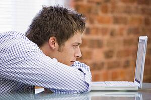 Businessman sitting in office with laptop