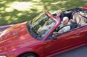 Couple in convertible car smiling