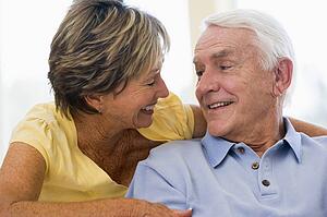 Couple relaxing in living room smiling
