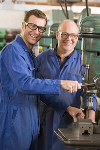 Two machinists working on machine
