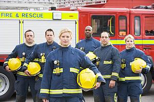 Six firefighters standing by fire engine