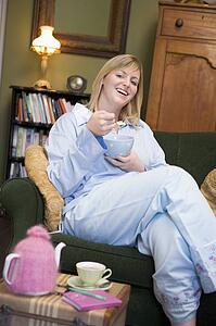 Young woman sitting at home eating a sweet treat