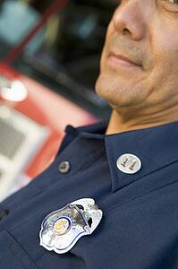 Fire captain with badge standing near fire engine (selective focus)