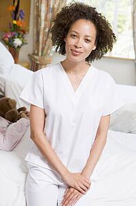 Nurse Sitting On Hospital Bed