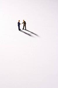 Figurines Of Two Businessmen Shaking Hands