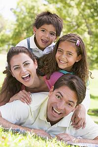 Family lying outdoors smiling