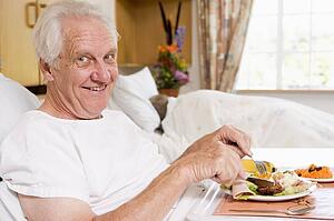 Senior Man Eating Hospital Food In Bad