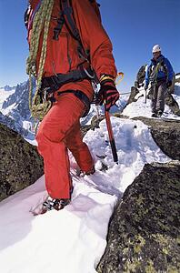 Two mountain climbers walking in snow (selective focus)