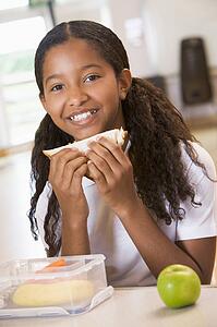 Student in cafeteria eating lunch (selective focus)