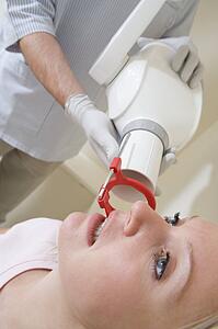 Dentist in exam room with woman in chair