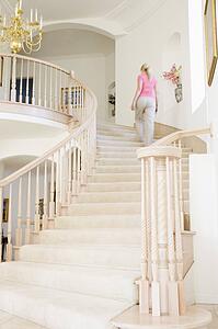 Woman going up staircase in luxurious home
