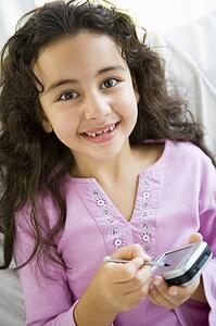 Young girl in living room with personal digital assistant smiling (high key)