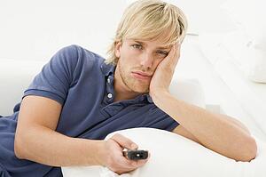 Man in living room holding remote control