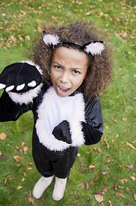 Young girl outdoors in cat costume on Halloween