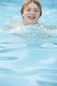 Young boy in swimming pool smiling