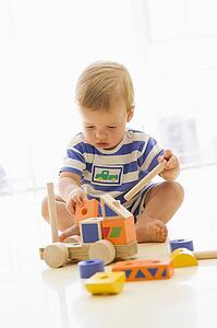 Baby indoors playing with truck