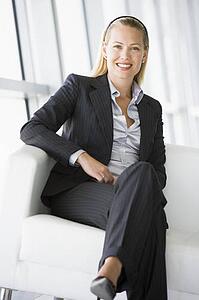 Businesswoman sitting in office lobby smiling