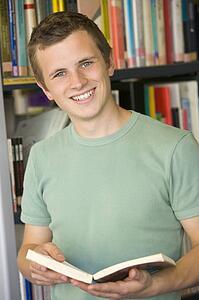 Man in library holding book