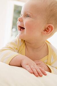 Baby lying indoors smiling