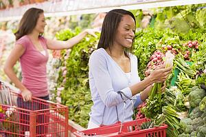 Women shopping for vegetables at a grocery store