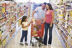 Mother and father with young daughter shopping at the grocery store.