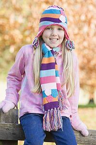 Young girl outdoors at park sitting on fence smiling (selective focus)