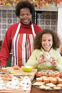 Grandmother and granddaughter making Halloween treats and smiling