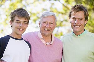 Grandfather with son and grandson smiling.