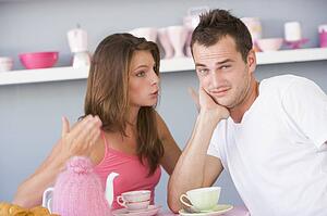Young couple sitting at a table arguing