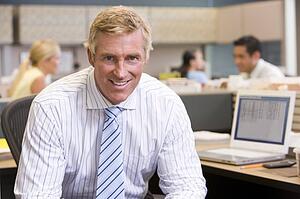 Businessman in cubicle smiling