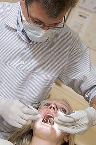 Dentist in exam room with woman in chair