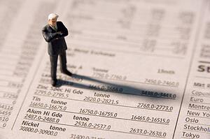 Figurine Of A Businessman With Arms Crossed Standing On A Financial Newspaper