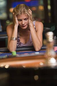 Woman in casino playing roulette and losing (selective focus)