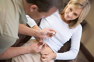 Man helping woman inject drugs to prepare for IVF treatment (selective focus)