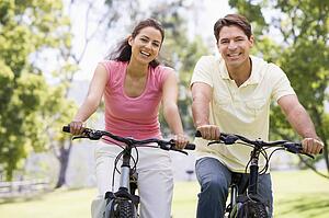 Couple on bikes outdoors smiling
