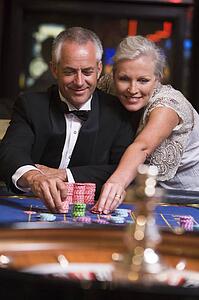 Couple in casino playing roulette and smiling (selective focus)