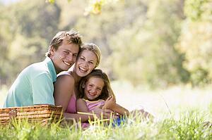 Family at park having a picnic and laughing